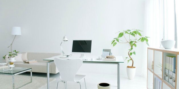 Home office in living room with potted plant