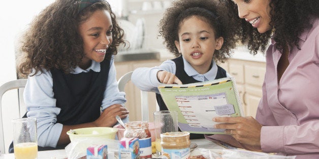 Mixed race mother going over homework with daughters