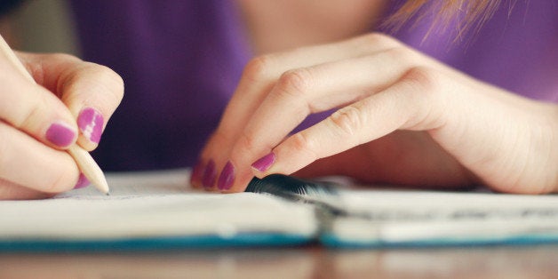 Girl writing in notebook.