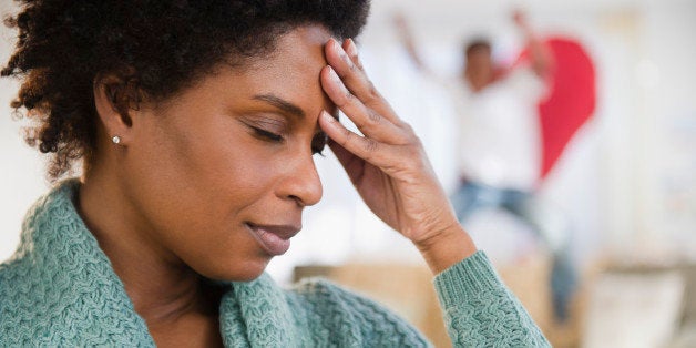 Black woman with headache and playful son in background