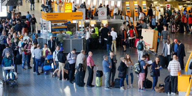 Passengers queue in front of the counters in a terminal at the airport as Lufthansa pilots went on a strike in Frankfurt, Germany, Wednesday, Sept. 9, 2015. The pilots ask for retirement arrangement under which pilots could retire at 55 and receive 60 percent of their salary until they reach the statutory retirement age of 65. (AP Photo/Michael Probst)