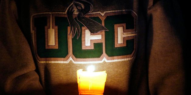 Diana Nicolay, a former employee of Umpqua Community College, wears a school sweatshirt during a candlelight vigil for those killed during a fatal shooting at the school Thursday, Oct. 1, 2015. (AP Photo/Rich Pedroncelli)