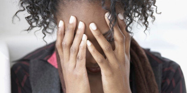 Young woman covering head in hands