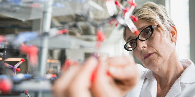 Close up scientist examining molecule model in laboratory