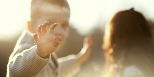 Child waving hand, little boy with mother outdoor