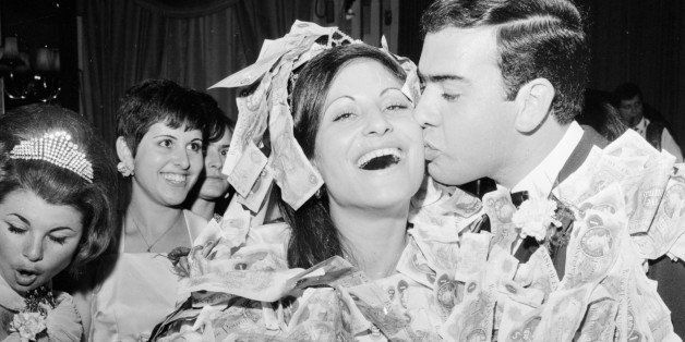 Fetin Mustafa and his wife, Dervise Paso, covered in money which was pinned on at their traditional Greek Cypriot wedding.