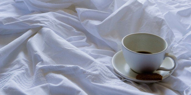 Coffee cup and cookie on bed