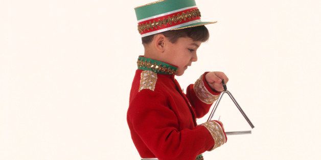 Boy in marching band uniform playing triangle while walking, side view