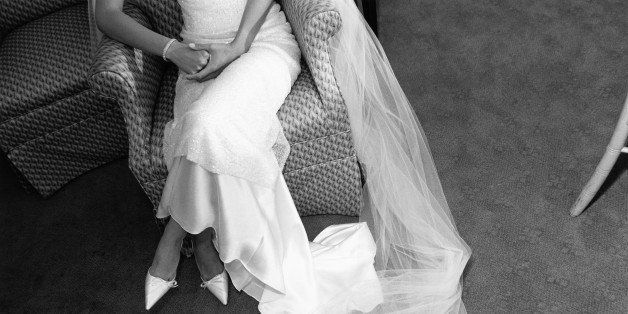 Bride sitting on chair, veil on floor (B&W)