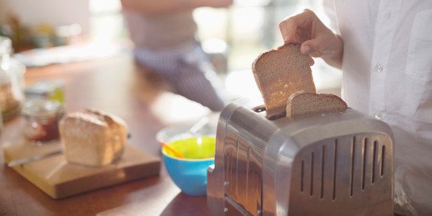 Woman putting bread in toaster