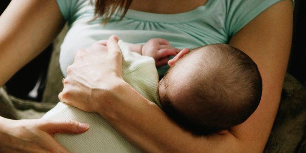 Close up of mother breast-feeding baby indoors