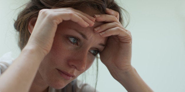 Depressed woman with head in hands