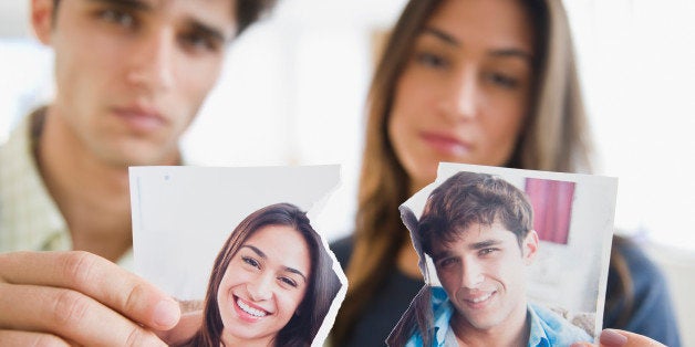 Couple holding torn photograph