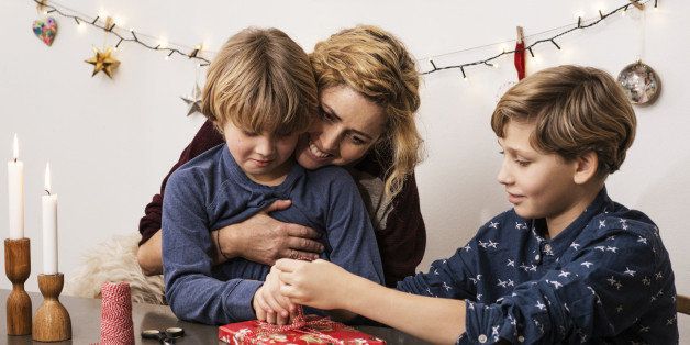 Mother and sons wrapping up Xmas parcel