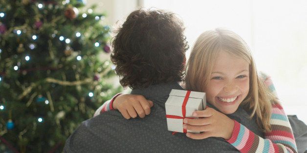 Daughter hugging father holding Christmas gift