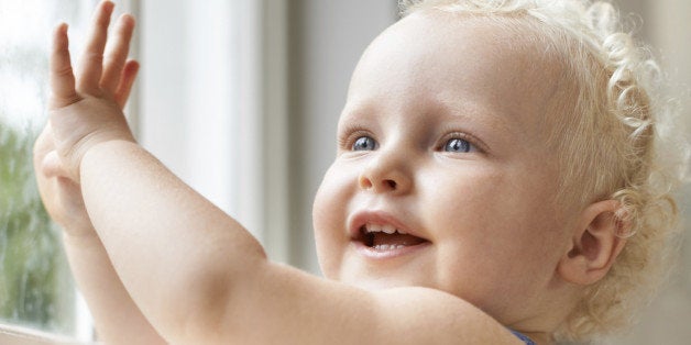 Closeup shot of an adorable baby fgirl with curly blond hair