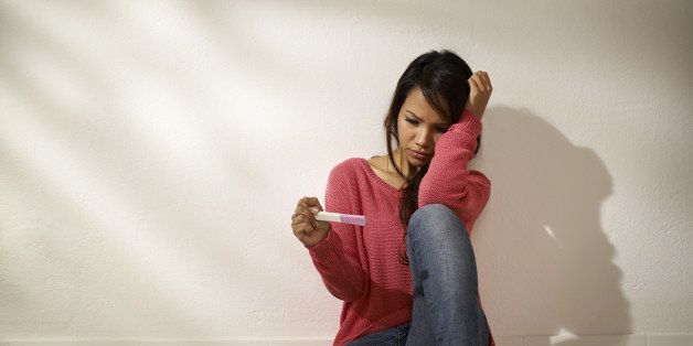 Women and health, anxious Asian girl looking at pregnancy test kit, sitting on ground at home