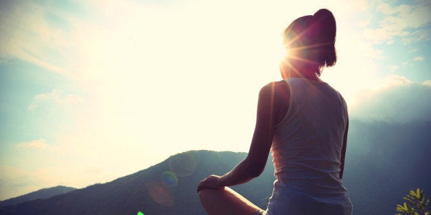 young yoga woman at sunrise mountain peak