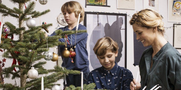 Mother and sons decorating X mas tree