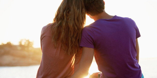 South Africa, Cape Town, Rear view of young couple sitting at beach