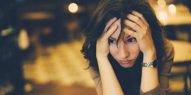 Portrait of a worried woman in cafe bar.