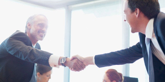 Businessmen shaking hands in conference room