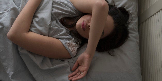 USA, New Jersey, Elevated view of young woman sleeping in bed