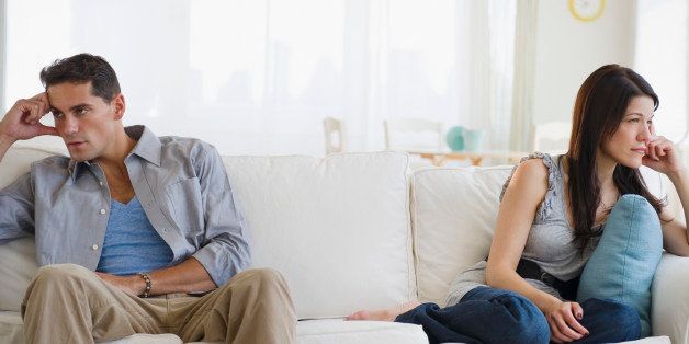 Angry mixed race couple having argument on sofa