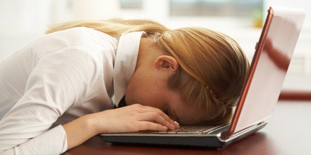 Image of very tired businesswoman or student with her face on keyboard of laptop Note to inspector: the image is pre-Sept 1 2009