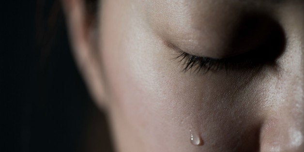 Young woman crying with tear drop.