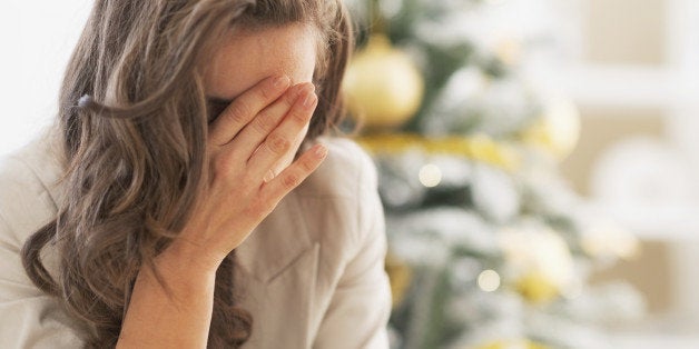 Stressed young woman in front of christmas tree