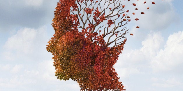 Brain disease with memory loss due to Dementia and Alzheimer's illness with the medical icon of an autumn season color tree in the shape of a human head and brain losing leaves as a concept of intelligence decline.