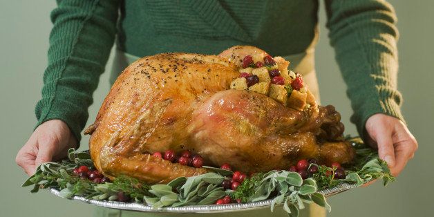 Man holding Thanksgiving turkey on decorated platter