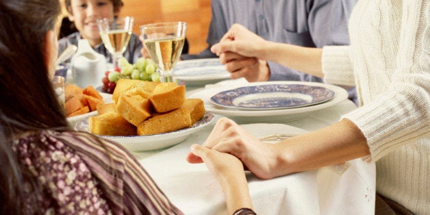 Portrait of a family saying grace before eating dinner