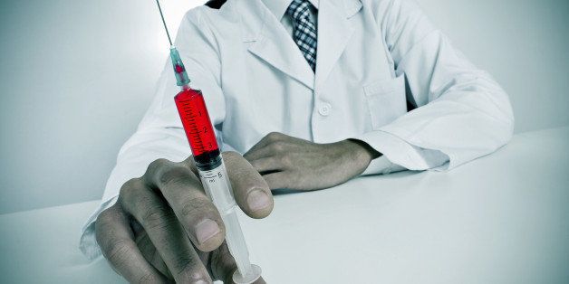 a sinister doctor sitting in a desk holding a syringe