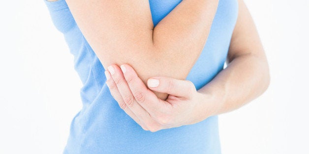 Woman touching her painful elbow on white background