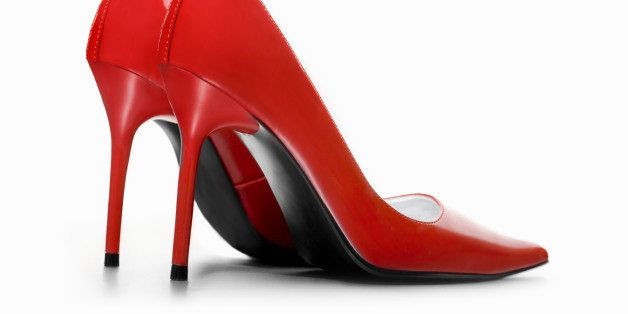 A pair of red high heeled shoes viewed from the side against a white background.