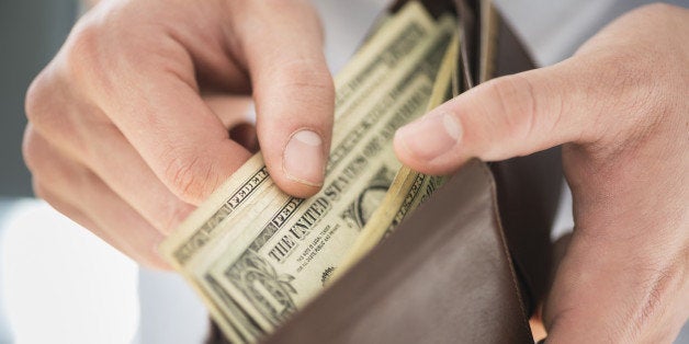 Young man holding wallet and counting money, Jersey City, New Jersey, USA