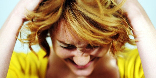 Portrait of a young woman running her hands through her hair.