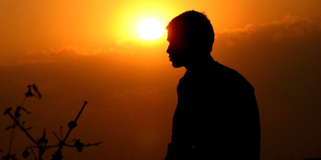 An Indian meditating at sunset