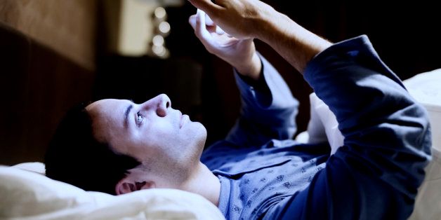 Man using his mobile phone in the bed