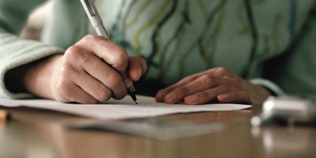 Woman writing on paper, close-up