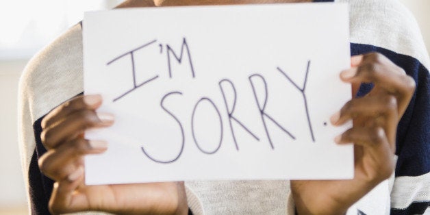 Mixed race woman holding ''I'm sorry'' sign