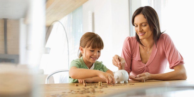 Mother and daughter filling piggy bank