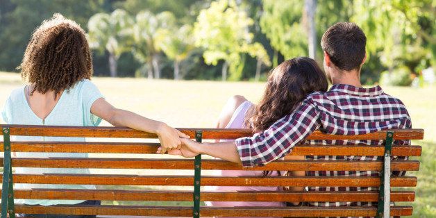 Lonely woman sitting with couple in park on a sunny day