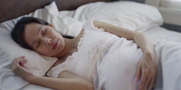 Pregnant woman lying in bed
