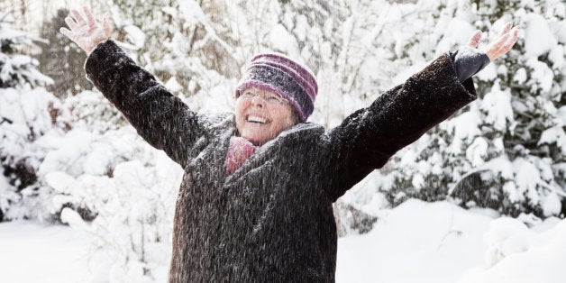 healthy senior woman outdoors, enjoying snow and winter
