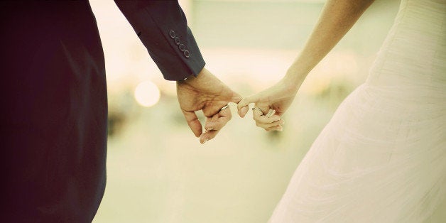 The hands of a marriage. Linked fingers two boyfriends after a wedding.Las manos de un matrimonio. Enlazados los dedos de dos novios tras una boda.