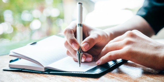 close up of woman writing her journal