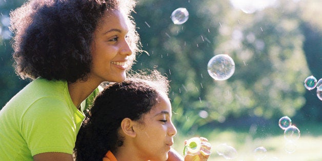 Mother and daughter blowing bubbles